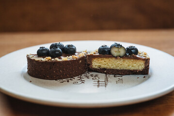 Delicious tartlet with chocolate and fresh blueberries, close-up. A refined European dessert.
