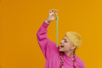 Young short-haired beautiful woman in necklace holding long sour candy