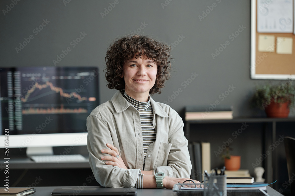 Aufkleber young successful female financial analyst sitting by workplace in office and looking at camera again