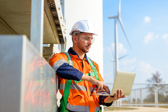 technician working outdoor at wind turbine field. Renewable energy engineer working on wind turbine projects, Environmental engineer research and develop approaches to providing clean energy sources