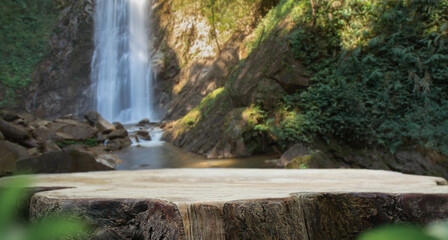 wood table top podium in outdoors waterfall green lush tropical forest nature background.organic healthy natural product present placement pedestal counter display,website banner cover jungle concept.