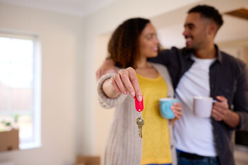 Fototapeta premium Excited Couple Unpacking Boxes Holding Keys To New Home On Moving Day