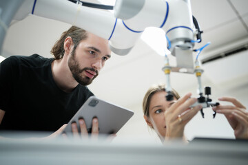 A female researcher at a start-up company examining a robot
