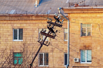 Fototapeta na wymiar Old rusty iron electrical pole with insulators and wires