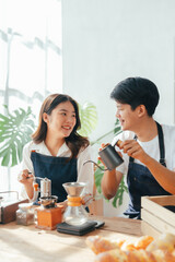 Young Asian couple doing holiday together in the kitchen happily wearing apron. love and valentine concept