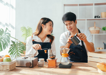 Young Asian couple doing holiday together in the kitchen happily wearing apron. love and valentine concept