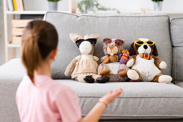 Little girl talking to fluffy toys