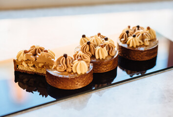 Shortbread tartlets with salted caramel and nuts. Sweet chocolate cakes. Modern mini desserts for candy bars, parties. Selective focus