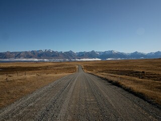 Dirt gravel Braemar Road leading to Lake Pukaki, Southern Alps mountain nature landscape panorama...