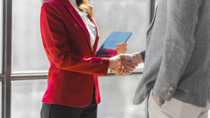 Working together business person with friends asian people in formal business suit red and blue color, bookkeepers receives good news by e-mail. Shaking hands