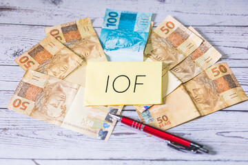 A sigla IOF referente ao Imposto sobre operações financeiras no Brasil escrita em um pedaço de...
