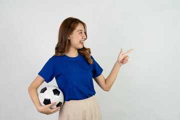 Happy Asian female soccer fan in blue shirt cheering for favorite team with soccer ball isolated on white background, pretty young pretty girl holding soccer ball, sports concept