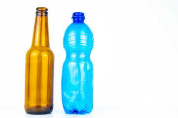 Brown glass bottle, next to blue plastic bottle. Recycle and reuse of plastic and glass. 
