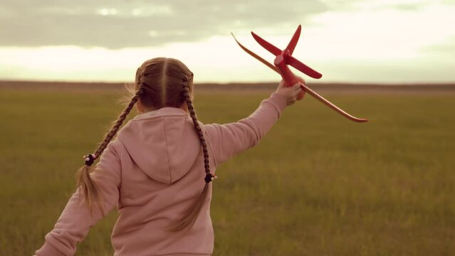 little cheerful child girl with airplane runs into sunset. happy family concept. childhood dream becoming airplane pilot. silhouette child playing with airplane. fly kid dream plane. run child pilot