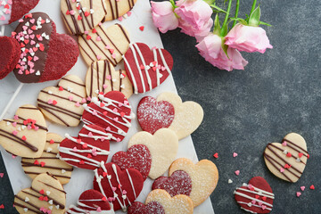 Valentines day cookies. Shortbread cookies inside sweet red heart with chocolate glaze on pink plate on grey background. Mothers day. Womans day. Sweet holidays baking. Valentines day card. Top view.