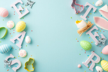 Top view photo of letters word easter colorful eggs bunny ears paws baking molds chicken in nest butterflies and sprinkles on isolated pastel blue background with copyspace