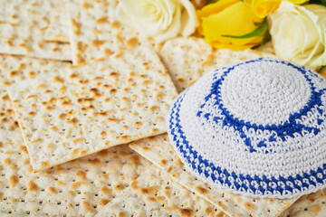 Passover celebration concept. Matzah, red kosher, white and yellow roses and walnut. Traditional...