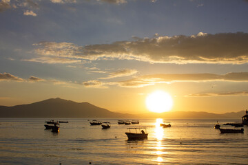 Boats floating on a lake at sunset