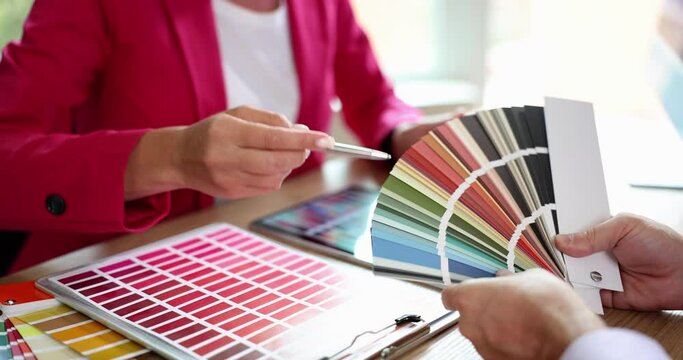 Meeting of designer and client in office discussing choice of color
