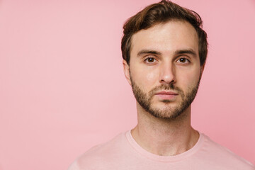 Fototapeta premium Young man looking at camera while posing isolated over pink background