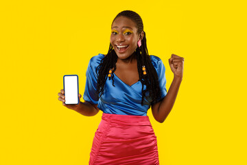 Joyful African American Lady Showing Smartphone Screen On Yellow Background