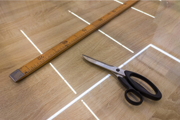 Tailor's scissors and wooden meter on the table