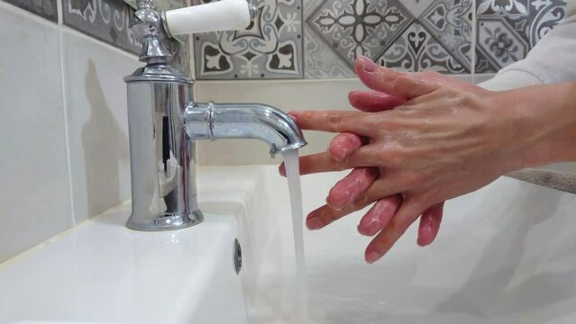 Process of cleaning of hands with water and soap in the bathroom, hygiene concept
