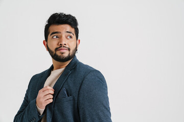 Indian guy looking aside while posing isolated over white background