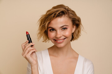 Portrait of woman posing with red lipstick isolated over beige background