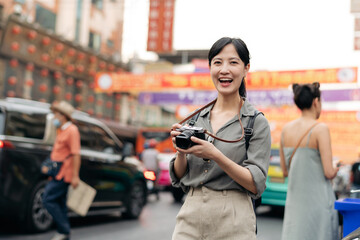 Young Asian woman backpack traveler enjoying China town street food market in Bangkok, Thailand. Traveler checking out side streets.