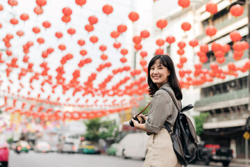 Young Asian woman backpack traveler enjoying China town street food market in Bangkok, Thailand. 