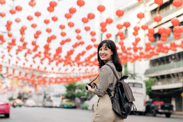 Young Asian woman backpack traveler enjoying China town street food market in Bangkok, Thailand. 