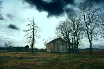 An old abandoned stable, the former splendor of the last century. dramatic clouds as a symbol of devastation and misery, a lonely old tree nearby. The course of historical events in time.