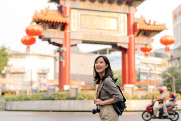 Young Asian woman backpack traveler enjoying China town street food market in Bangkok, Thailand.