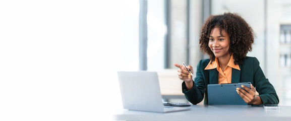 Online consult with laptop, video conference, Young pretty african american business woman bookkeepers working with balance sheet yearly reports to calculate tax and online consult in modern office.
