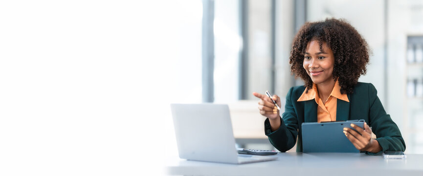 Online consult with laptop, video conference, Young pretty african american business woman bookkeepers working with balance sheet yearly reports to calculate tax and online consult in modern office. - Powered by Adobe