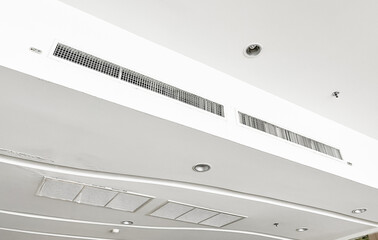 Ceiling mounted cassette type air conditioner and modern lamp light on white ceiling. duct air...