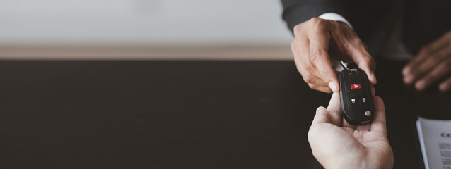 A car rental company employee pointed out the renter to sign the rental agreement after discussing...