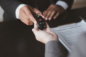 A car rental company employee pointed out the renter to sign the rental agreement after discussing the details and rental terms with the renter. Concept of car rental.