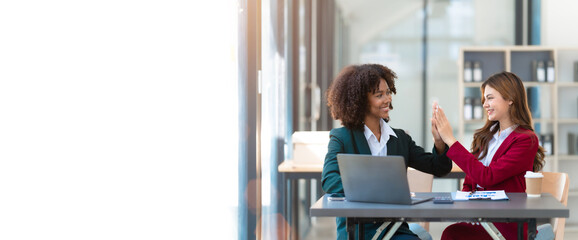 Young trader mixed race woman in formal suit friends consulting and discussing with stock market and cryptocurrency in online trading application.