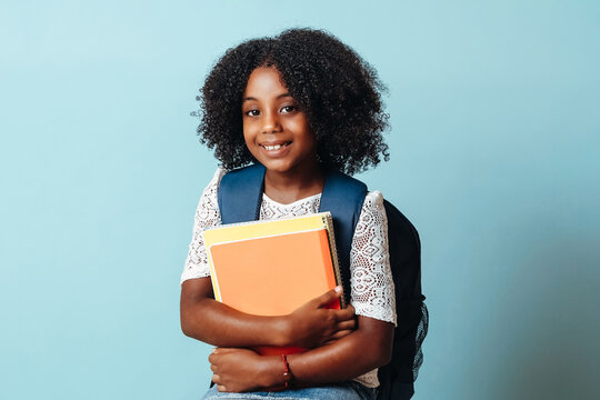 Student girl with bag holding notebooks.