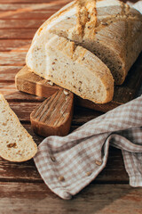 Bread loaf on rustic wooden cutting board and napkin