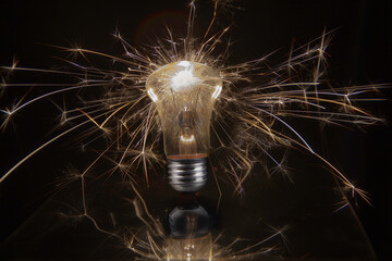 an electric light bulb sparks in all directions on a black background
