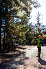 Obraz premium boy with a backpack in the forest. The child is standing in the middle of the road in the forest.