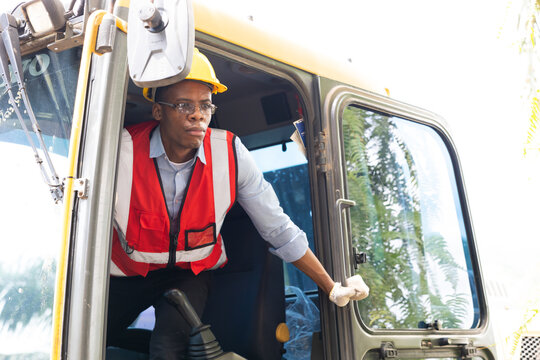 Portrait african american young Male construction worker operating on Skid tractor or construction vehicle at building site.