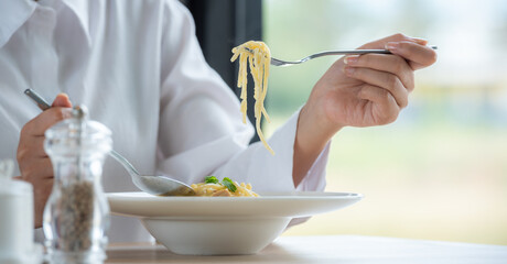 Banner of Woman in white clothes holding and smell white dish plate with pasta homemade spaghetti...
