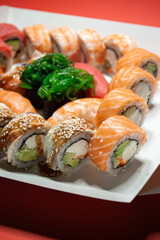 salmon tuna chuka shrimp eel nigiri gunkan sushi rolls set in white box on red background