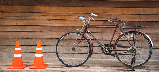 Banner panorama size of Vintage bicycle on old rustic dirty wall house, many stain on wood wall. Classic bike bicycle on decay brick wall retro style. Cement loft partition and window background.