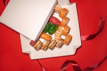 salmon tuna chuka shrimp eel nigiri gunkan sushi rolls set in white box on red background