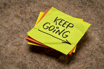 keep going - motivation or determination concept - handwriting on a sticky note